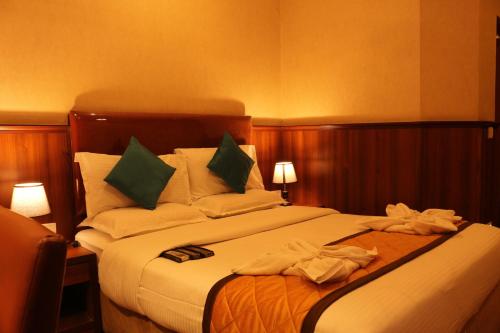 a hotel room with a bed with towels on it at Hotel Noor Empire International Kormangala in Bengaluru