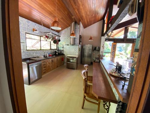 a large kitchen with wooden cabinets and a counter at Casa Mirante do Prata no Vale das Videiras in Araras Petropolis