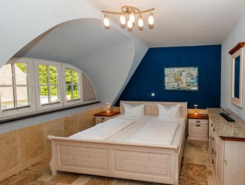 グロース・シュヴァンセにあるVilla DUXCAARの青い壁のベッドルーム1室(大型ベッド1台付)