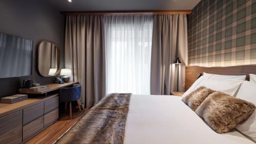 a bedroom with a large white bed and a mirror at Bor Hotel by Karisma in Zlatibor