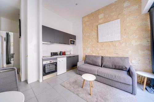 un salon avec un canapé et une cuisine dans l'établissement Beautiful apartment Bordeaux with private terrace, à Bordeaux