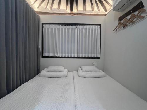 um quarto com 2 camas e uma janela em Hanok Dasi Bom em Gyeongju