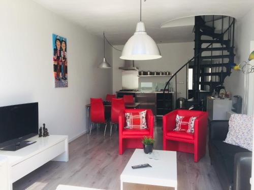 a living room with red chairs and a couch at Holiday in Spakenburg Groof in Spakenburg