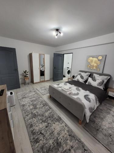 - une chambre avec un grand lit et un tapis dans l'établissement Apartament cu 1 camera, à Zalău