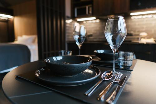 a table with two glasses and a plate of food and a wine glass at Black Beach Suites in Vík