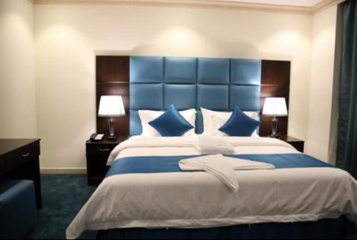 اجنحة ميلان في جدة: غرفة نوم مع سرير كبير مع اللوح الأمامي الأزرق