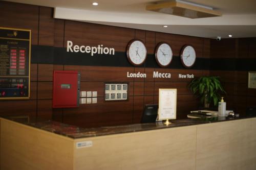 a restaurant with three clocks on the wall at اجنحة ميلان in Jeddah