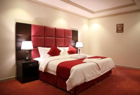a bedroom with a large bed with a red headboard at اجنحة ميلان in Jeddah