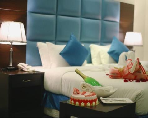 a hotel room with a bed with a blue headboard at اجنحة ميلان in Jeddah