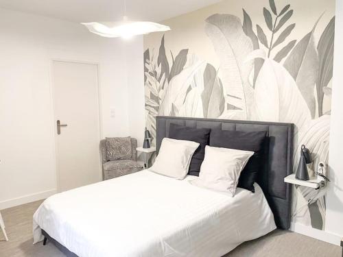 a bedroom with a white bed with a plant wall at Studio Jungle N2 in Alençon
