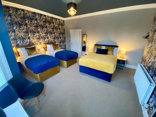 1 Schlafzimmer mit 2 Betten in Blau und Gelb in der Unterkunft LFC 6 Bedroomed House sleeps 14 in Liverpool