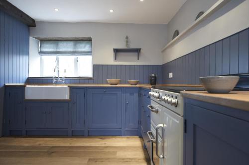 a kitchen with blue cabinets and a sink at Sky in Sharrington