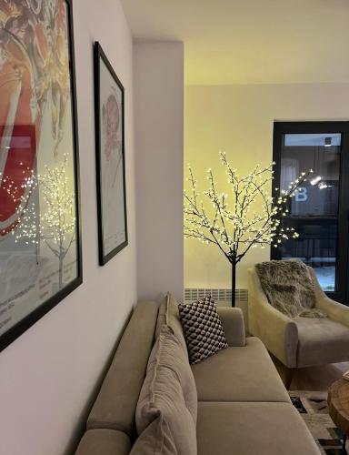 a living room with a couch and a tree at Arbor Apartment in Bjelašnica