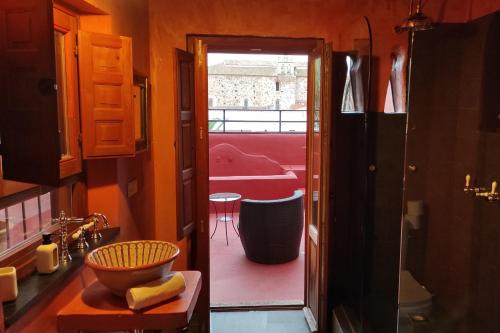 Baño con puerta que da a una habitación roja en Hotel la Boheme en Cáceres