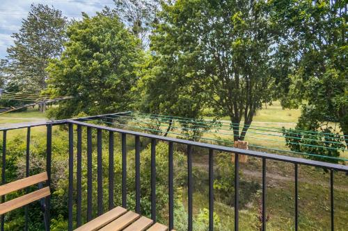 a balcony with a bench and a field with trees at Sunny Studio Opolska with Balcony in Gdańsk by Renters in Gdańsk