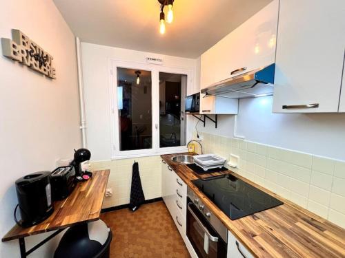 une cuisine avec un comptoir en bois dans une pièce dans l'établissement Le P'tit Montreuillois - Appartement proche Paris, à Montreuil