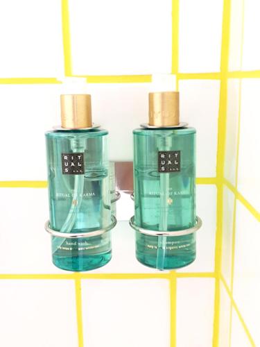 two green bottles on a shelf in a bathroom at Vera Cruz Suite Apartment in Aveiro
