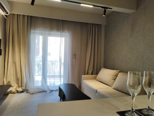 a living room with a couch and two wine glasses at Sea Stars 2 APARTMENT in Perea