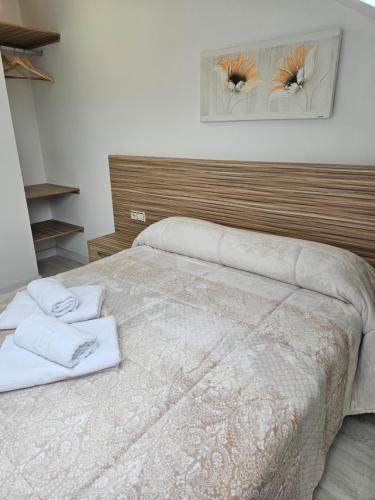 a bedroom with a bed with two towels on it at Alojamientos turísticos Sinagoga in Úbeda