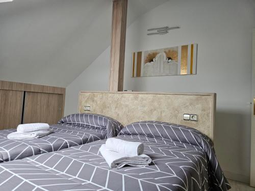 a bedroom with two beds with towels on them at Alojamientos turísticos Sinagoga in Úbeda