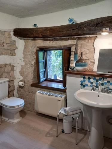 a bathroom with a sink and a toilet and a window at Sotto il fico in Agnino