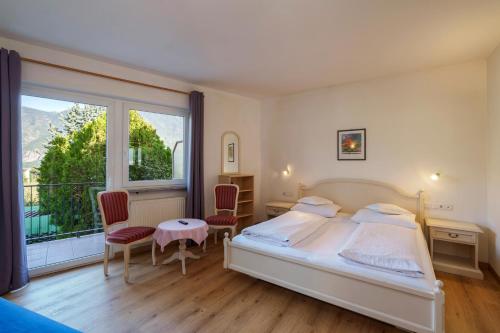 a bedroom with a bed and a large window at Hotel Appartement Lahngut in Nalles