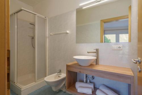 La salle de bains est pourvue d'un lavabo, de toilettes et d'une douche. dans l'établissement Hotel Appartement Lahngut, à Nalles