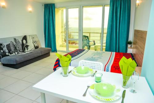 a living room with a bed and a table with plates at Апартаменти Дача in Varna City