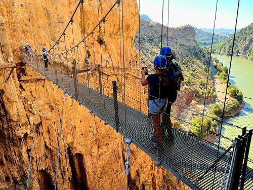 a man standing on a suspension bridge on a mountain at Glamping Vive Tus Suenos -Equilibrio- Caminito del Rey in Alora
