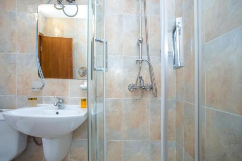 La salle de bains est pourvue d'un lavabo et d'une douche en verre. dans l'établissement Studio - Apartments Castle Complex 2, à Pamporovo