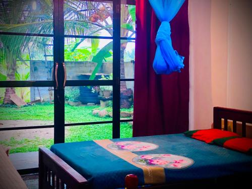 Schlafzimmer mit einem Bett und einem Fenster mit Aussicht in der Unterkunft Residence Inn in Angunakolapelessa