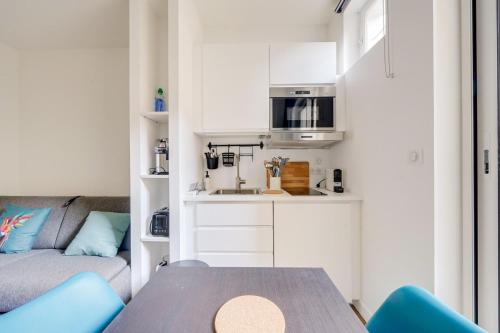 ein kleines Wohnzimmer mit einem Tisch und einem Sofa in der Unterkunft Lovely studio in Chartrons with terrace in Bordeaux