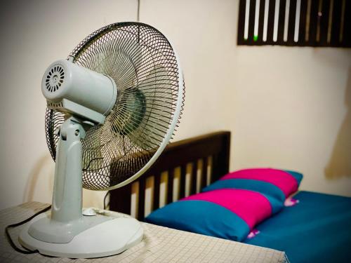 un ventilador blanco sentado en una mesa junto a una cama en Residence Inn, en Angunakolapelessa