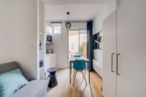 Dieses kleine Apartment verfügt über einen Schreibtisch, ein Bett und eine Küche. in der Unterkunft Lovely studio in Chartrons with terrace in Bordeaux