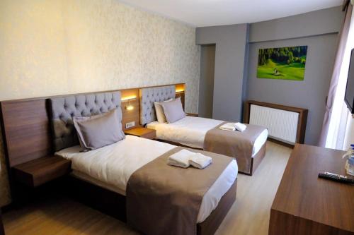 a hotel room with two beds and a desk at GRAND SALİZZE HOTEL in Kestel