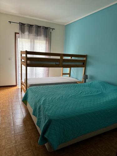 sypialnia z łóżkiem piętrowym i zieloną narzutą w obiekcie Apartament Pedro&Pérolla w mieście Gafanha da Vagueira