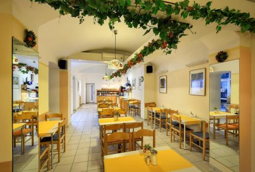 un restaurant vide avec des tables et des chaises jaunes dans l'établissement Residence Tabor, à Prague