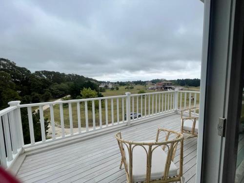 a balcony with two chairs and a view of the beach at El Salto Suites - Casonas del Haras in Mar del Plata