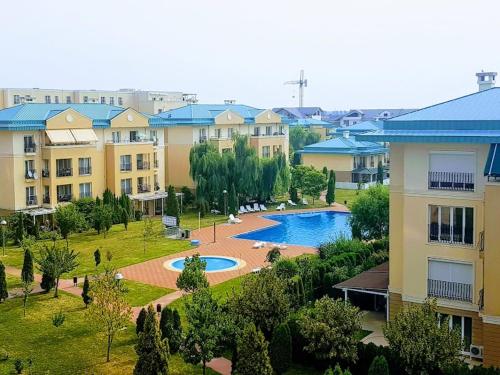an apartment complex with a swimming pool in a park at Comfort cosmopolis in Ştefăneştii de Jos