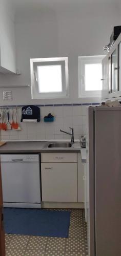 cocina con fregadero y nevera en Casa Belo Horizonte, en Praia da Barra