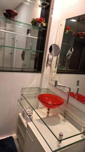 a red stool sitting on a glass counter in a bathroom at Loft em Belém in Belém