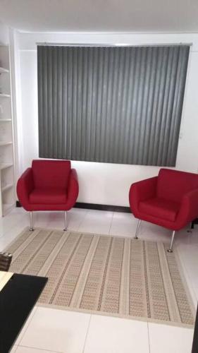 duas cadeiras vermelhas num quarto com uma janela em Loft em Belém em Belém
