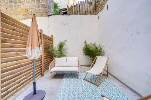 un patio avec deux chaises et un parasol dans l'établissement Beautiful apartment in Chartrons with terrace, à Bordeaux