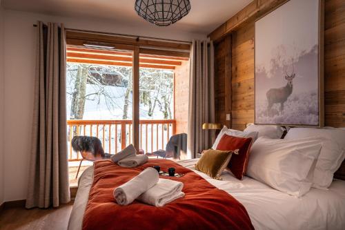 une chambre avec un grand lit avec des serviettes dessus dans l'établissement Appartement Rêve des Neiges, aux Gets