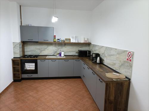 una cucina con mobili bianchi e un piano di lavoro di Casa OALPEM a Rîşnov