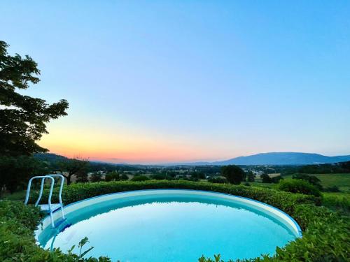 a swimming pool with a sunset in the background at Scappo in Umbria,Mevania in Bevagna
