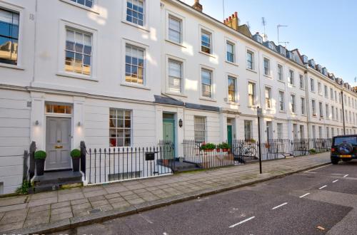 a row of white houses on a city street at Victoria Belgravia Townhouse Apartments in London