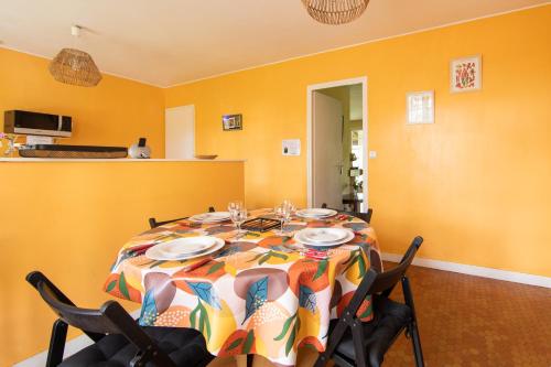 a dining room with a table with plates and chairs at Cantebos - Maison avec 3800 m² de jardin in Saint-Laurent-de-Médoc