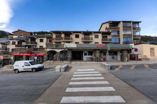 a white car parked in front of a building at Tetras 66 - Station de ski à pied in Les Angles
