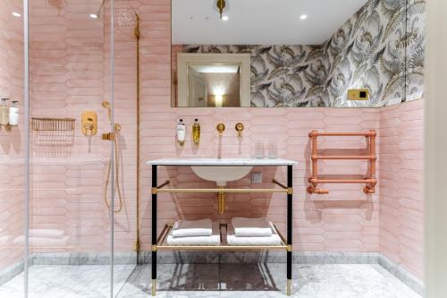 a pink bathroom with a sink and a shower at Hotel Unicus Palace Old Town - Destigo Hotels in Kraków